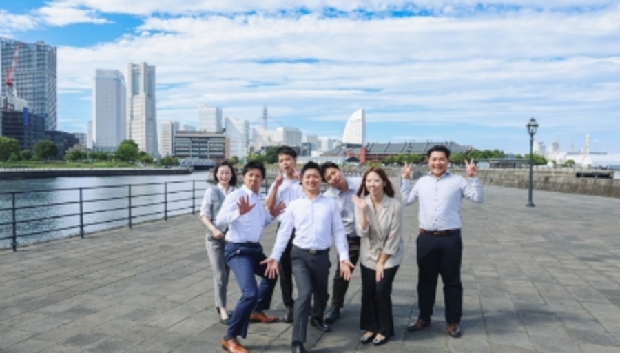 木製の家のミニチュアに虫眼鏡をかざし、不動産を精査する様子を表現した写真