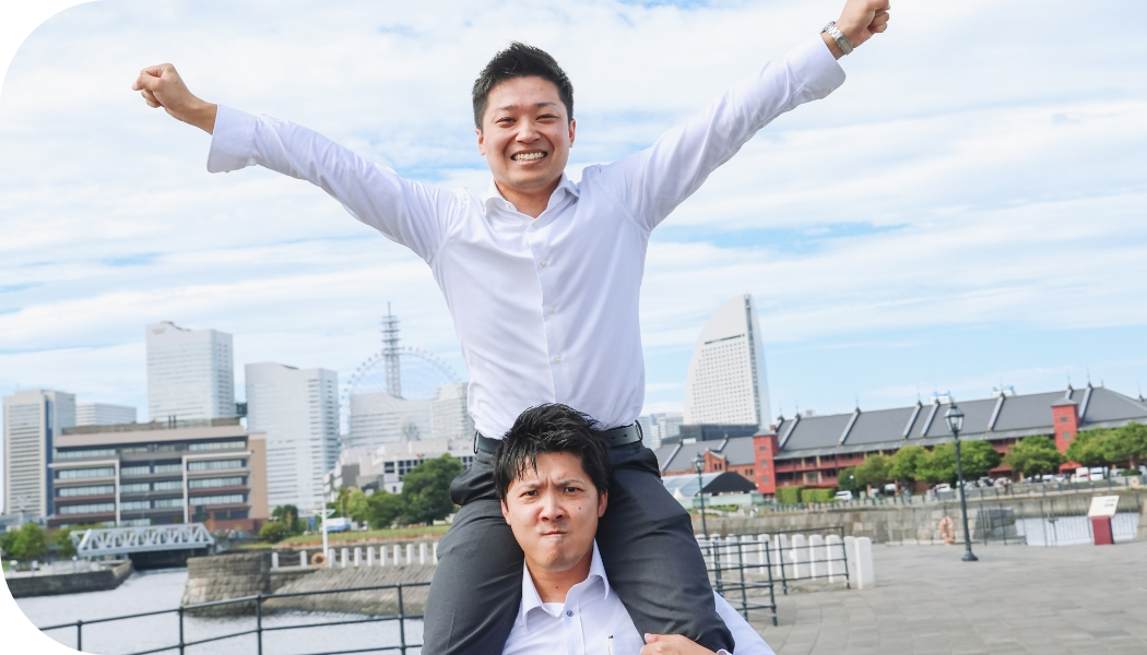 スーツ姿の男性と女性が室内のエアコンを見上げている様子