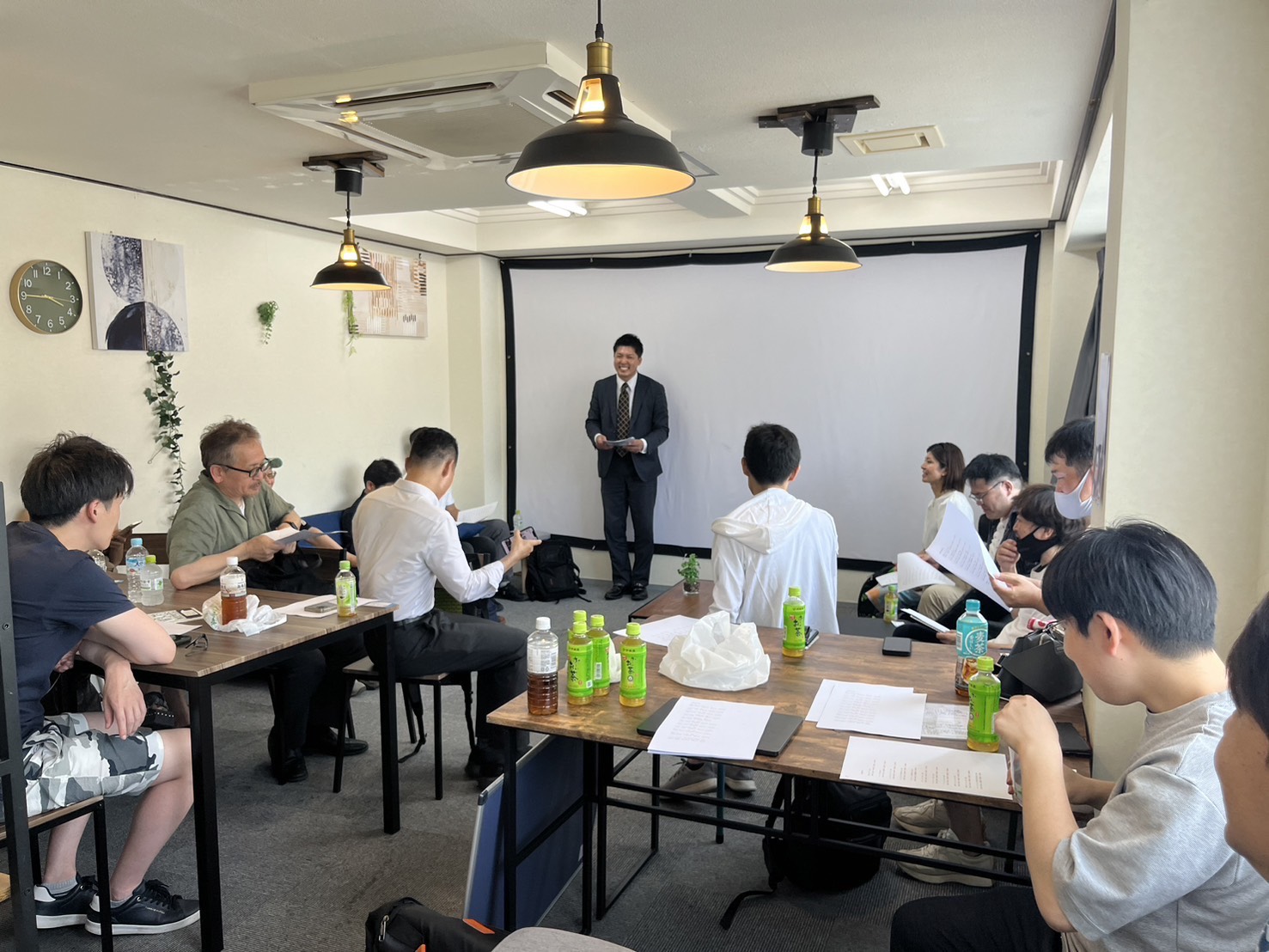 家の模型とコインの山にパーセントマークが重ねられた不動産投資のイメージ